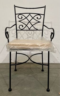 une image représentant une chaise en fer noir sur laquelle est posé un coussin