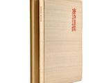 an old book with chinese writing on it sitting on top of a white surface