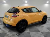 the rear end of a yellow nissan juke suv on a checkered floor