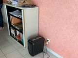 a woman standing next to a small refrigerator in a room