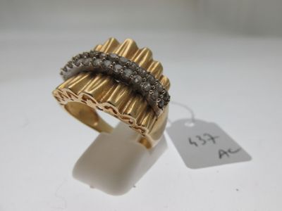gros plan d'une bague en or avec des diamants sur une surface blanche