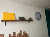 a shelf with a laptop on it and a clock on the wall