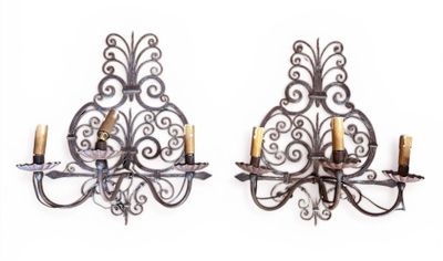 Suite de TROIS APPLIQUES en fer forgé éclairant à trois bras…