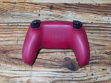 a close up of a red controller on a wooden table