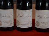 three bottles of wine are lined up on a table