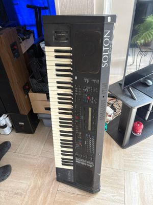 a piano that is sitting on the floor next to a keyboard
