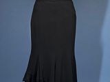 black and white dress on a mannequin stand against a blue background