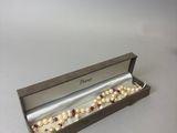 un gros plan d'une boîte contenant un collier de perles