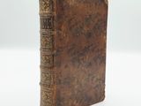 an old book sitting on top of a white surface