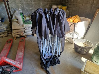 un tas de vêtements suspendus à un portant dans un garage