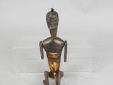 bronze figurine of a man with a mohawk on his head sitting on a clear base