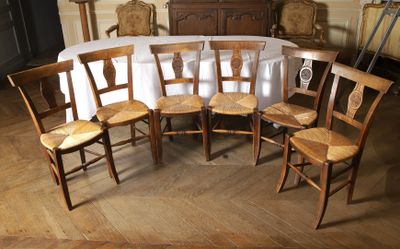 six chaises disposées autour d'une table recouverte d'une nappe blanche
