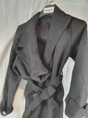 une veste grise avec une cravate sur le devant et une chemise noire sur un cintre