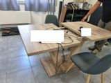 un homme debout à côté d'une table sur laquelle se trouve un ordinateur portable