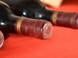 three bottles of wine sitting on a red table