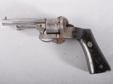 a silver revolver on a white surface with a black handle
