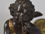 a statue of a little boy smoking a cigarette in front of a clock