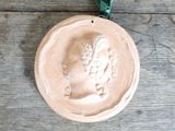 a ceramic ornament of a woman with a green ribbon