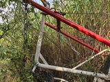 a red and white bike that is leaning against a tree