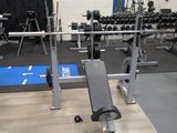 an image of a gym room with a bench and weights