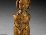 une vieille figurine en bois représentant une femme tenant un bébé dans ses bras