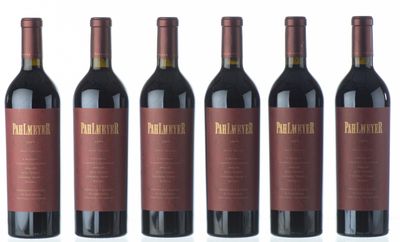 six bouteilles de vin rouge sont alignées sur une surface blanche