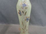 a yellow vase with blue flowers on it sitting on a table