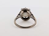 a close up of a ring with a white stone in it