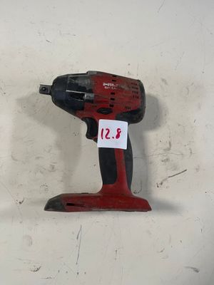 une perceuse sans fil rouge posée contre un mur blanc