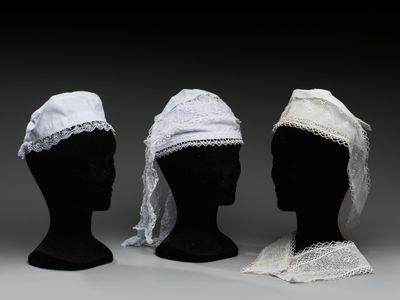 trois têtes de mannequins noires ornées de dentelle blanche