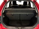 the back of a red car with its trunk open and the seats folded down