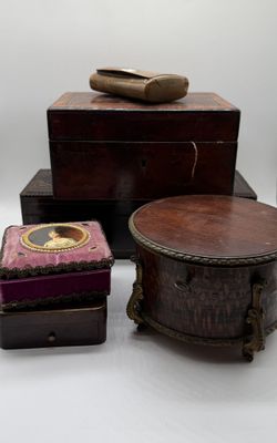 three wooden boxes and a pair of shoes on a white surface