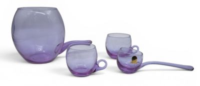 trois verres violets et une cuillère posés sur une surface blanche