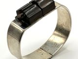 silver ring with black stones on top of it on a white surface