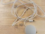 un câble blanc branché à un chargeur posé sur une table en bois