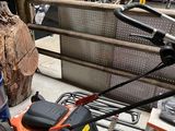 a small lawn mower sitting on the floor next to a pile of tools
