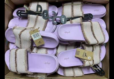 plusieurs paires de chaussures dans une boîte, avec leurs étiquettes