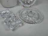 three glass dishes and a glass candle holder on a table