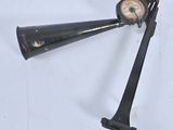 a very old black clock with a long horn