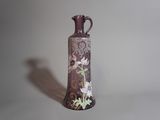 un vase violet orné de fleurs, posé sur une table