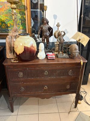 une commode sur laquelle sont posés de nombreux objets