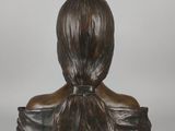 a bronze statue of a woman with a ponytail on her head