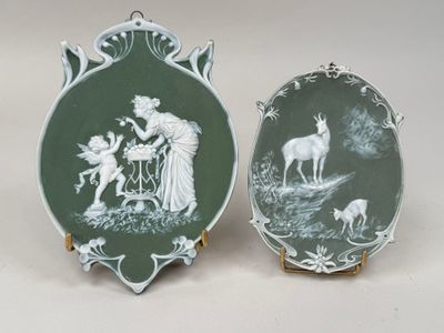 two green and white plates with a picture of a woman and a deer