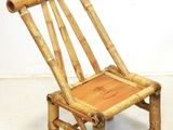 une petite chaise faite de tiges de bambou posée sur un sol blanc