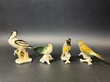 trois petites figurines d'oiseaux et un oiseau posé sur une table