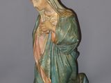 the statue of the virgin mary is sitting on the ground