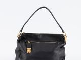un sac à main en cuir noir avec des ferrures dorées sur la poignée