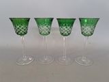 four green glass goblets sitting next to each other on a table