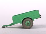 a green toy truck that is sitting on a white surface