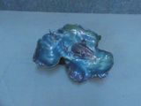 une broche en forme de fleur bleue et verte sur un fond blanc
